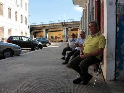 ...incrociamo alcuni uomini seduti davanti a una bottega. Ci presentiamo e uno di loro, Luigi, ci racconta che in questa via �portano le auto rubate, prima di chiedere il riscatto�